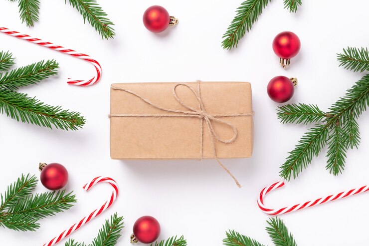 Photo christmas composition with fir tree branches, decoration and present box on white background