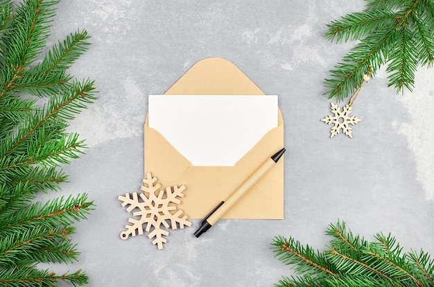 Christmas composition with fir tree branches and envelope with empty card and pen