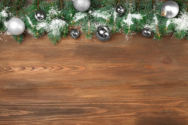 Christmas composition with fir tree branches and festive decoration on wooden background