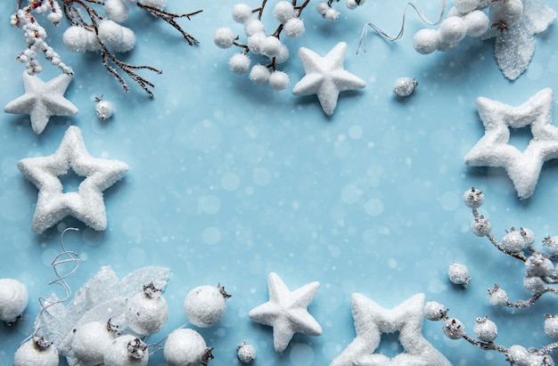 Christmas composition with frame made of white decoration on pastel blue surface