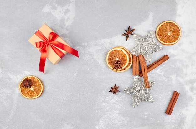 Christmas composition with gift box, dry oranges and spices