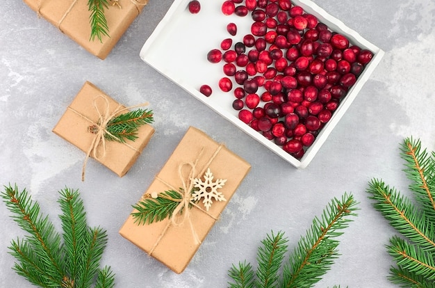 Christmas composition with gift boxes, cranberries and fir tree branches