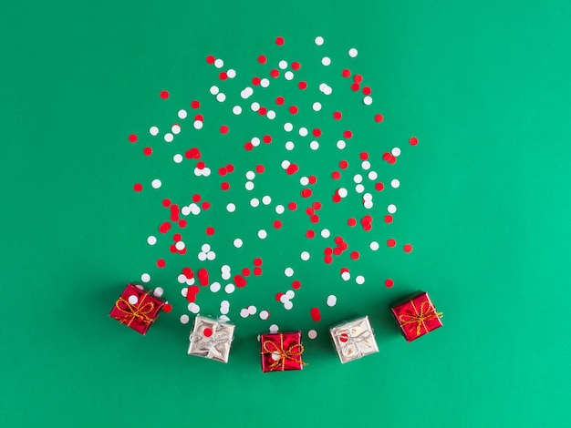 Christmas composition with gift and colorful confetti on green background new year holiday concept