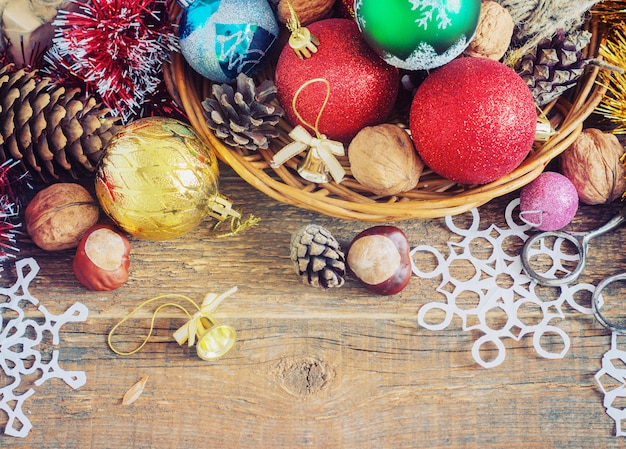 Christmas Composition with Gifts. Basket, red balls, pine cones, snowflakes on Wooden Table. Vintage style