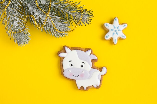 Christmas composition with gingerbread bull on the yellow background