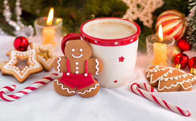 Christmas composition with gingerbreads candles lollipops homemade cookies and a mug of coffee