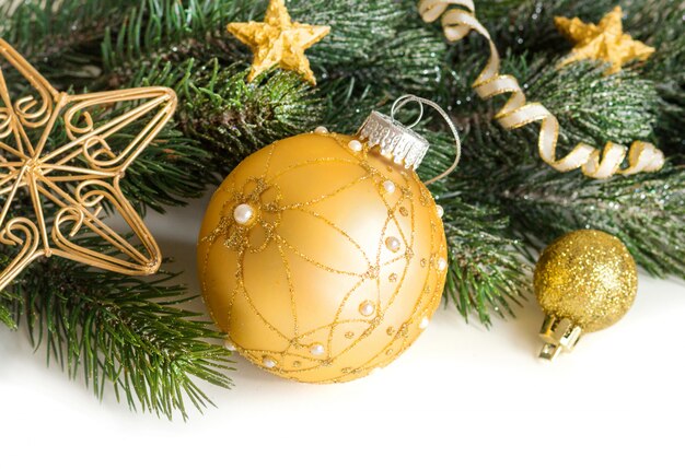 Christmas composition with golden bauble, decorations and branches isolated on white close up