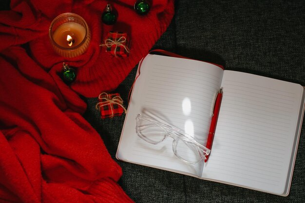 Рождественская композиция с блокнотом, ручкой, очками, свечой и декором