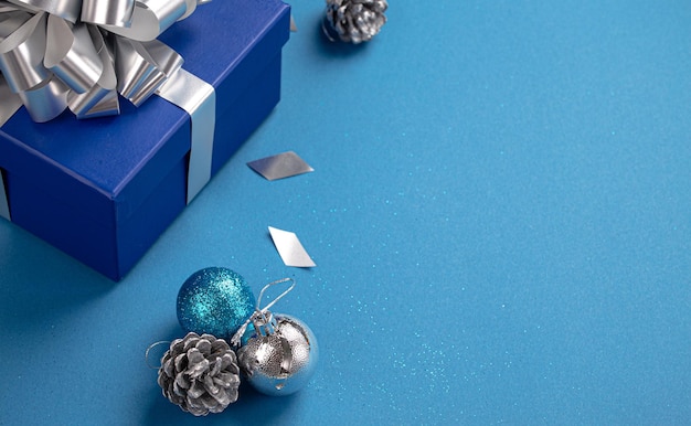 Christmas composition with present and decorations in blue and silver colors