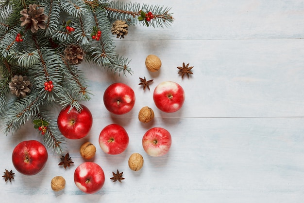 Christmas composition with red apples, walnuts, cinnamon and other ingredients and access