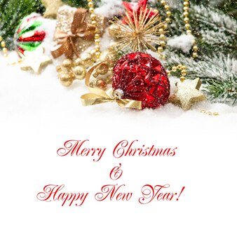 Composizione natalizia con palline rosse e decoro dorato con effetto neve che cade. concetto di carta con testo di esempio buon natale e felice anno nuovo