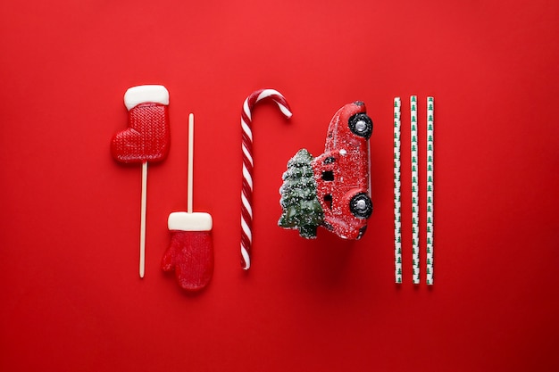 Christmas composition with a red car on red. Flat lay composition.