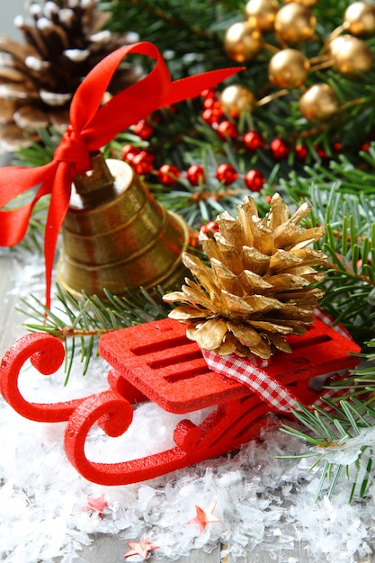 Рождественская композиция с санями, шишкой и колокольчиком