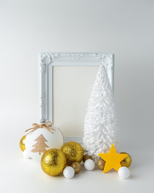 Новогодняя композиция с белой рамкой и золотым новогодним украшением
