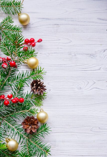 Christmas composition with xmas tree and red berries on white table