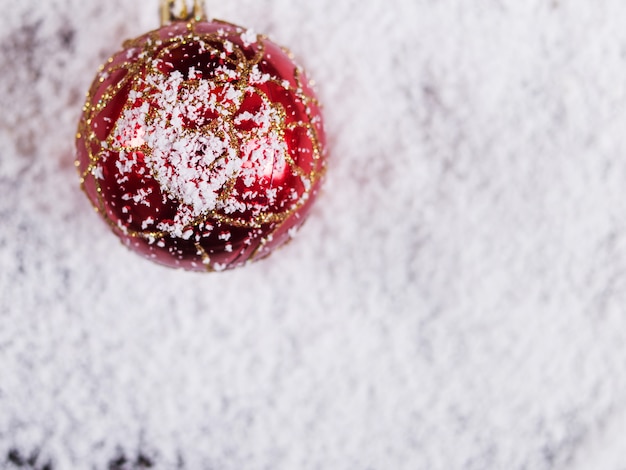 Christmas concept background, Christmas ball toy on white snow, holiday symbol.