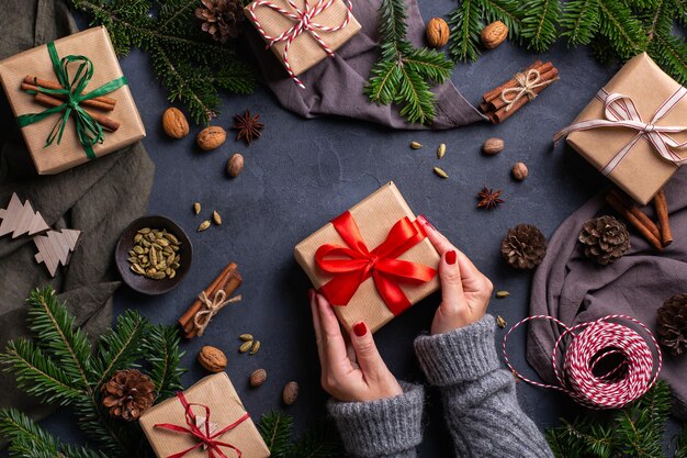 Рождественские концепции женские руки, упаковывающие экологически чистые подарочные коробки ручной работы