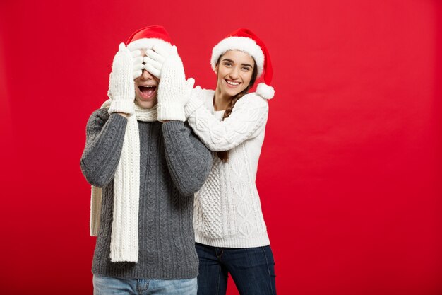 Christmas Concept - portrait lovely girlfriend surprising close her boyfriend eyes in Christmas day.