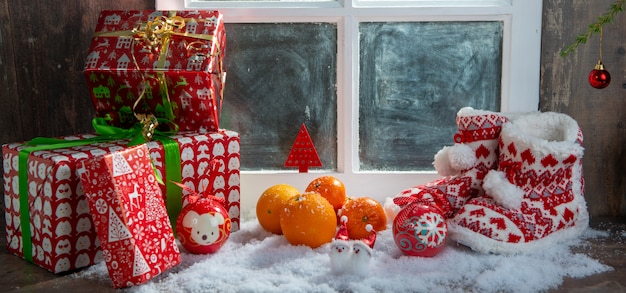 Christmas concept with slippers, oranges and gifts