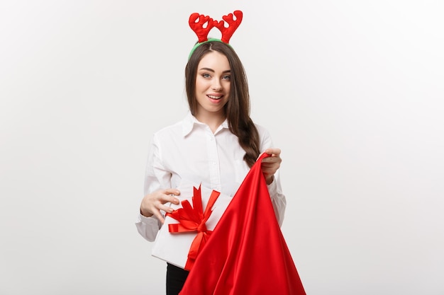 Christmas Concept Young beautiful business woman happy with present in santa bag