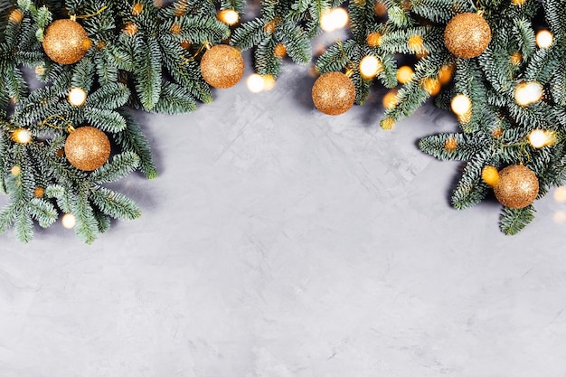 Christmas concrete background with fir tree and golden toys and lights