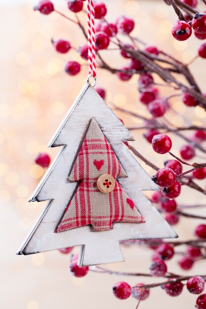 Foto cono di natale con bacche rosse su uno sfondo bokeh di fondo.