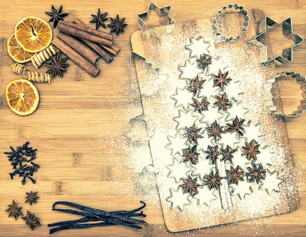 Christmas cookie cinnamon stars and spices on wooden background. vanilla pods, cloves, star anise and cinnamon. vintage style toned picture