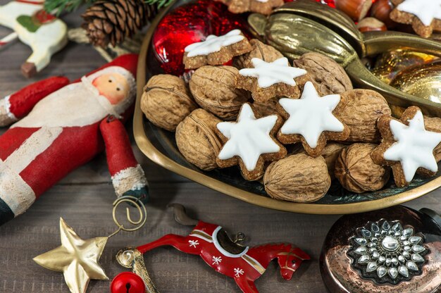 Фото Рождественское печенье и грецкие орехи со старинными украшениями на деревянных фоне