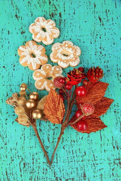 Christmas cookies and decorations on color wooden background