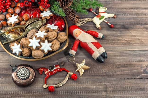 Biscotti natalizi e noci con decorazioni vintage su fondo in legno wooden