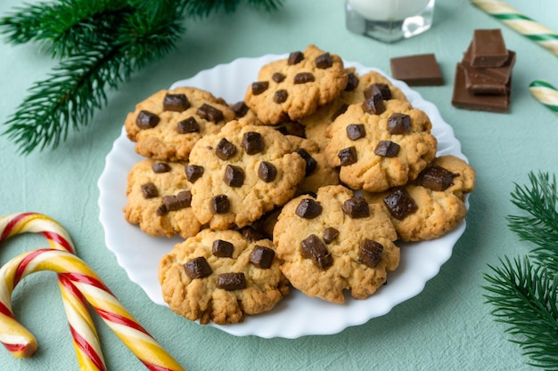 Christmas cookies with chocolate chips on blue textile background.