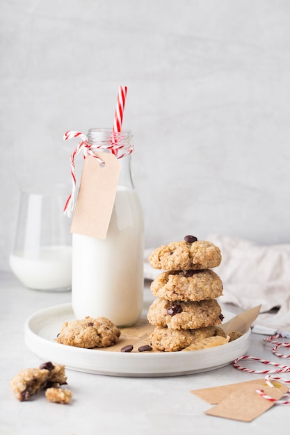 Christmas cookies with chocolate on a plate milk bottle on a white table