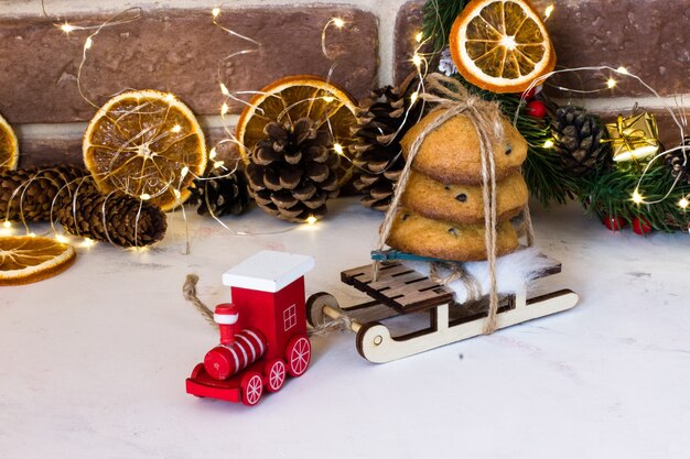 Foto biscotti di natale al cioccolato su slitte e locomotiva rossa