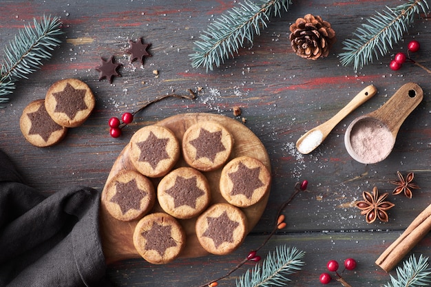 Christmas cookies with chocolate star on a table with cocoa, cinnamon and decorated fir twigs