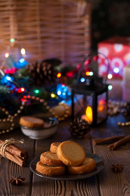 夜の居心地の良い設定の垂直写真でお祝いの装飾が施されたクリスマス クッキー