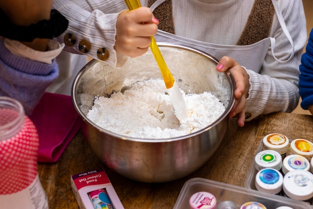 クリスマス クッキー ワークショップ 小麦粉を混ぜる女の子の手のクローズ アップ