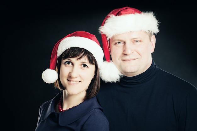 Christmas Couple. Man and Woman in Santa Hat on Blackboard Background