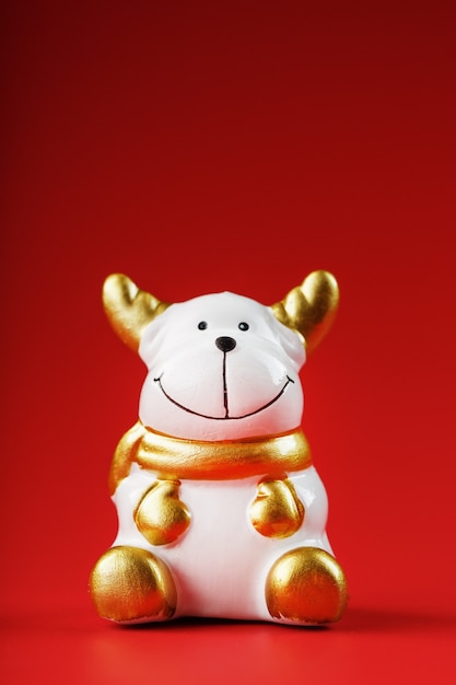 Christmas cow figurine on a red wall. Symbol of the new year of the bull 2021. Isolate