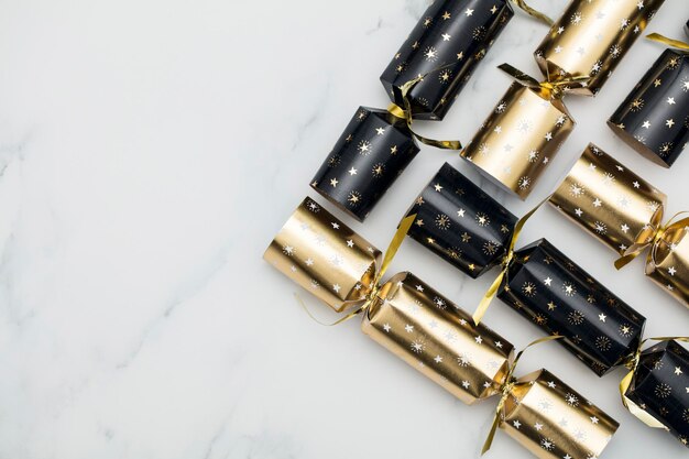 Фото Рождественские крекеры роскошные золотые и черные праздничные крекеры на мраморном фоне