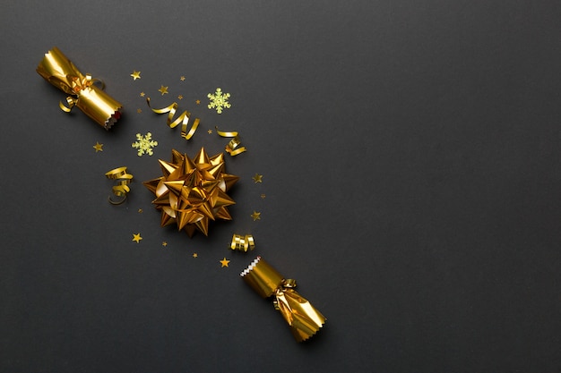 Christmas crackers with shiny confetti on color background, top view, copy space