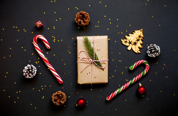 Christmas craft gift box with pine cones, candy canes and confetti