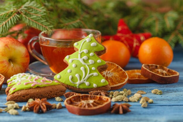 お茶と木製のテーブルの上のスパイスのクリスマスカップ