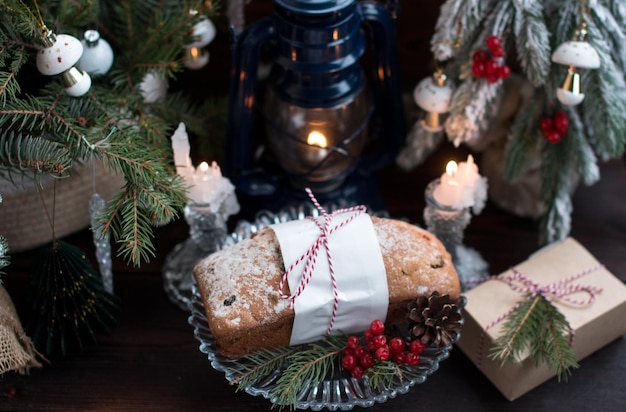 빛이 있는 크리스마스 트리의 배경에 있는 크리스마스 컵케이크 밀가루 제품을 제공