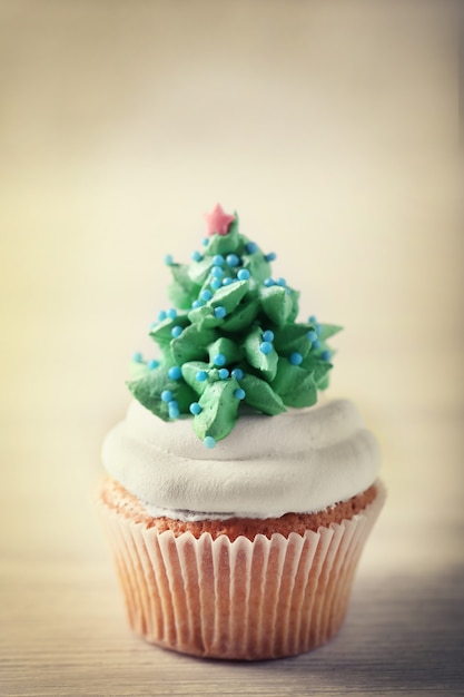 Christmas cupcake on light surface