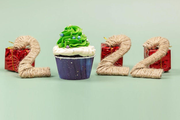 Foto cupcakes di natale e 2022 su sfondo verde punto di messa a fuoco selettiva per il testo