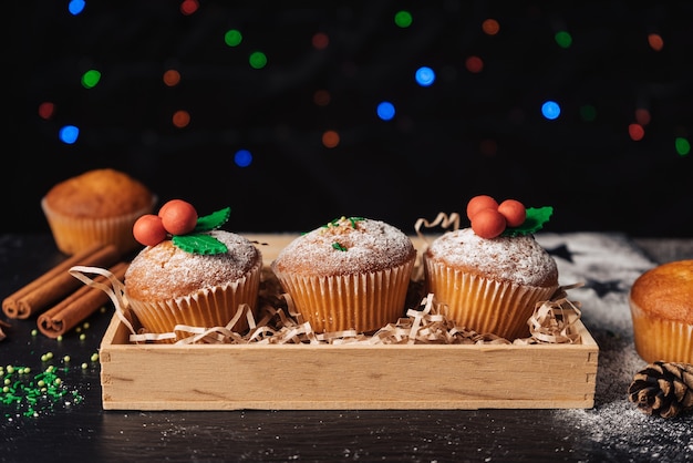 木製の箱にヤドリギで飾られたクリスマスカップケーキ