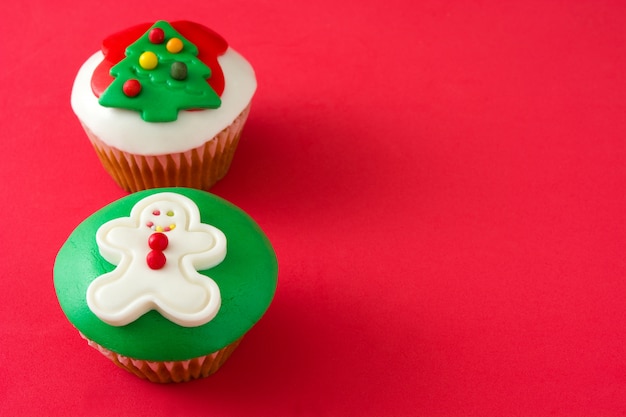 Christmas cupcakes on red background copy space