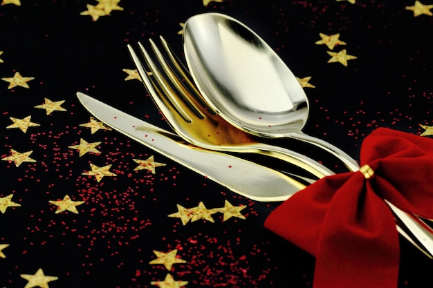 Christmas cutlery Spoon fork and knife stacked up on a starry background