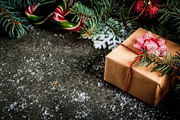 クリスマスツリーの枝、松ぼっくり、キャンディー杖お菓子、ギフト、クリスマスボール、装飾とクリスマスの暗い背景