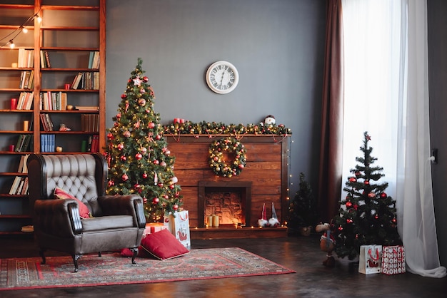 Christmas dark interior albero di natale sempreverde con decoro rosso camino poltrona e libreria